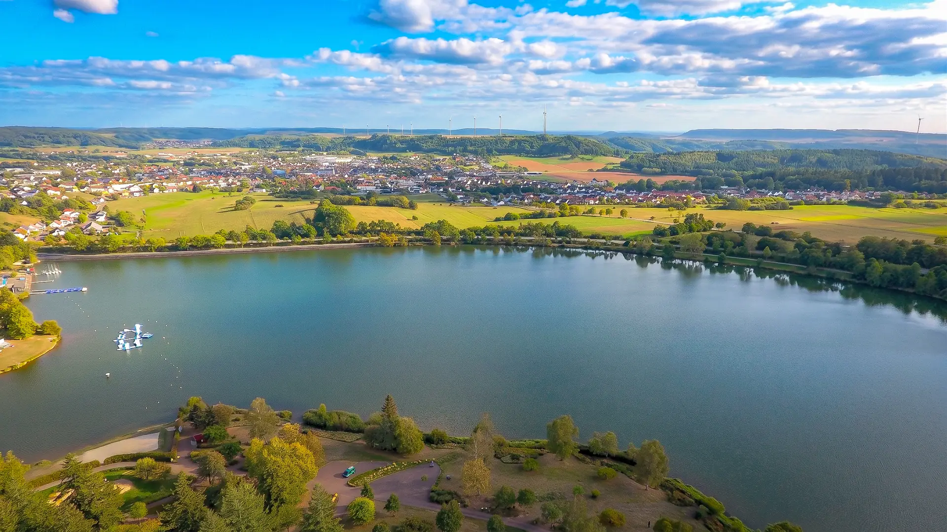Luftaufnahme von Losheim am See mit dem Stausee und dem Ortskern dahinter